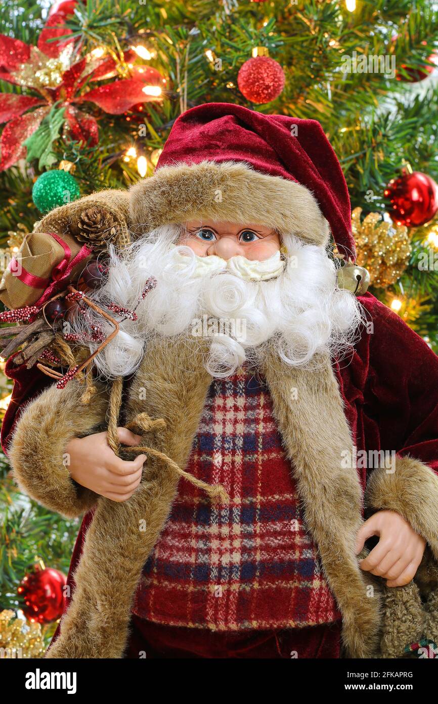 Père Noël portant un sac plein de cadeaux avec Arrière-plan flou de l'arbre de Noël Banque D'Images