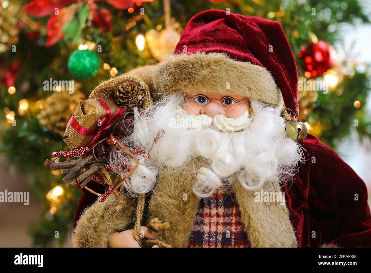 Père Noël portant un sac plein de cadeaux avec Arrière-plan flou de l'arbre de Noël Banque D'Images