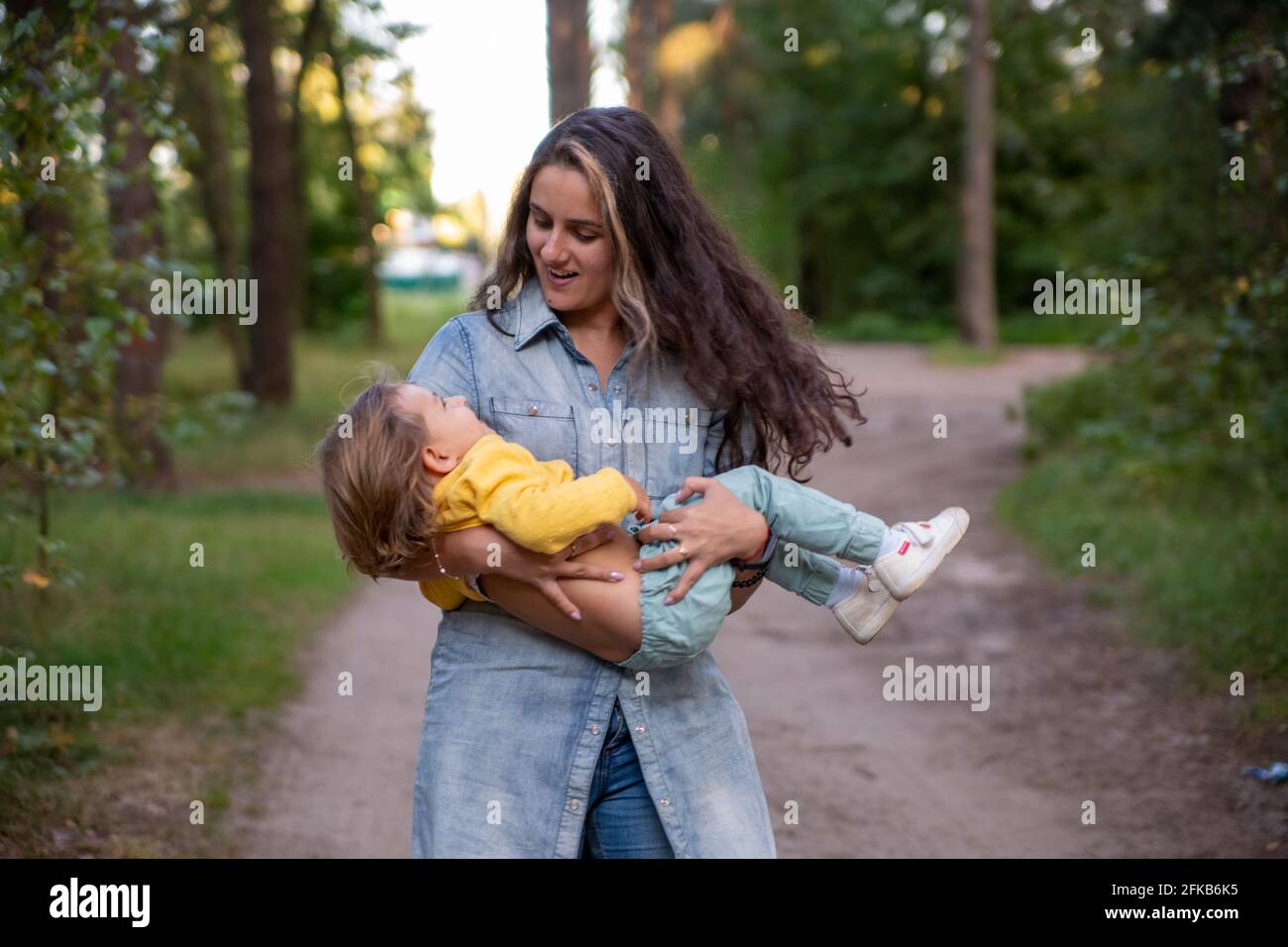 La Jeune Mere Tourne Avec Un Bebe Dans Les Bras Bonne Maman Dansant Avec Un Tout Petit Sur Le Fond De La Nature Et De La Foret Maman Et Fille Rient Photo Stock