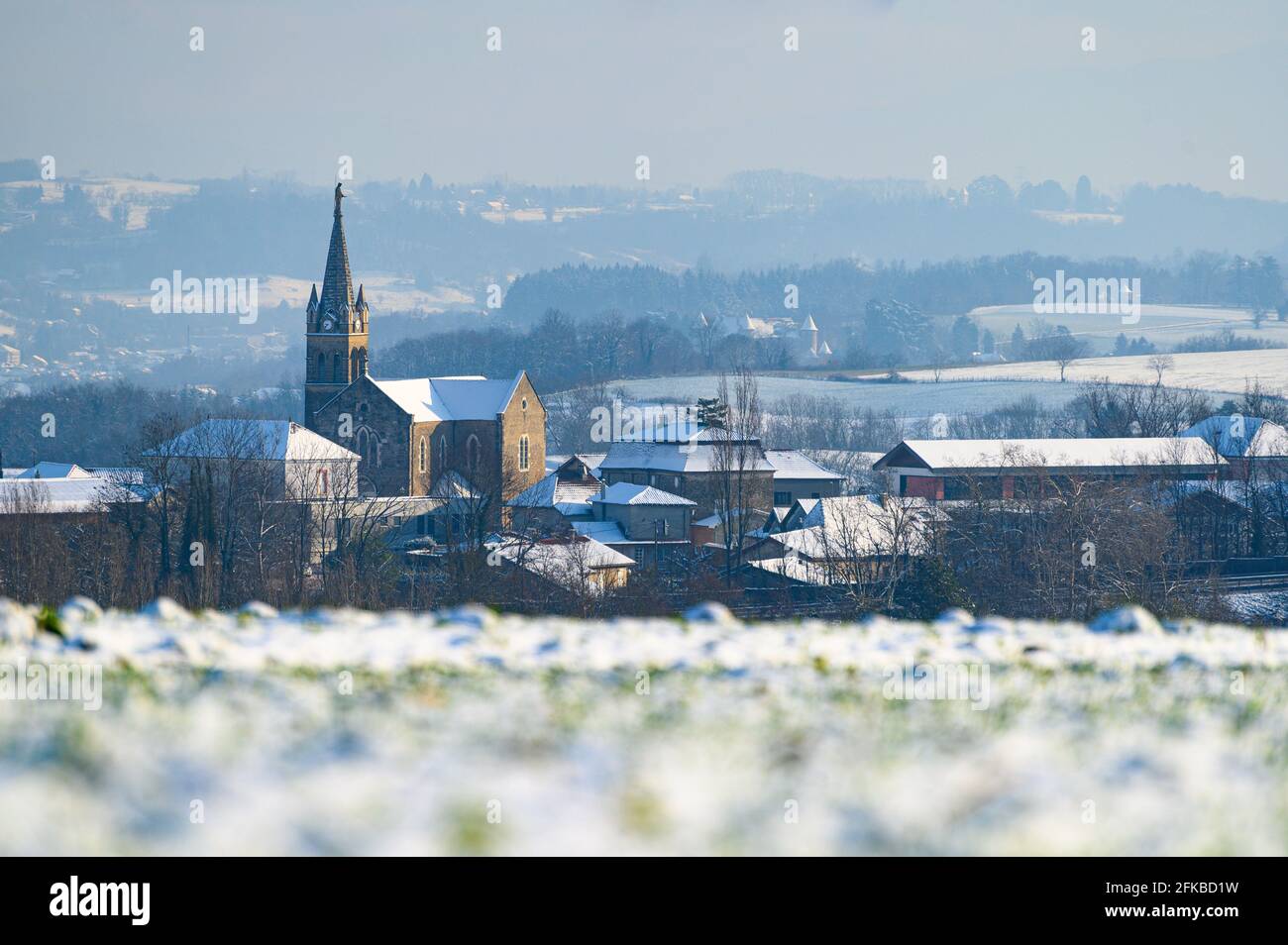 Photo d'une église enneigée prise à distance avec de la neige en premier plan. Banque D'Images