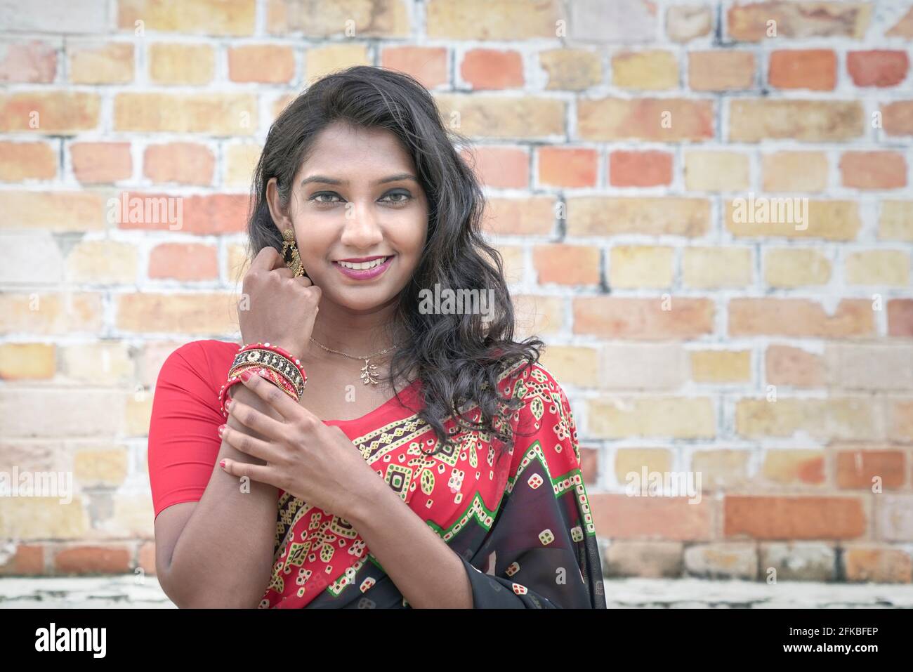 Portrait d'une belle femme indienne souriante portant une saree rouge. Copier l'espace. Banque D'Images