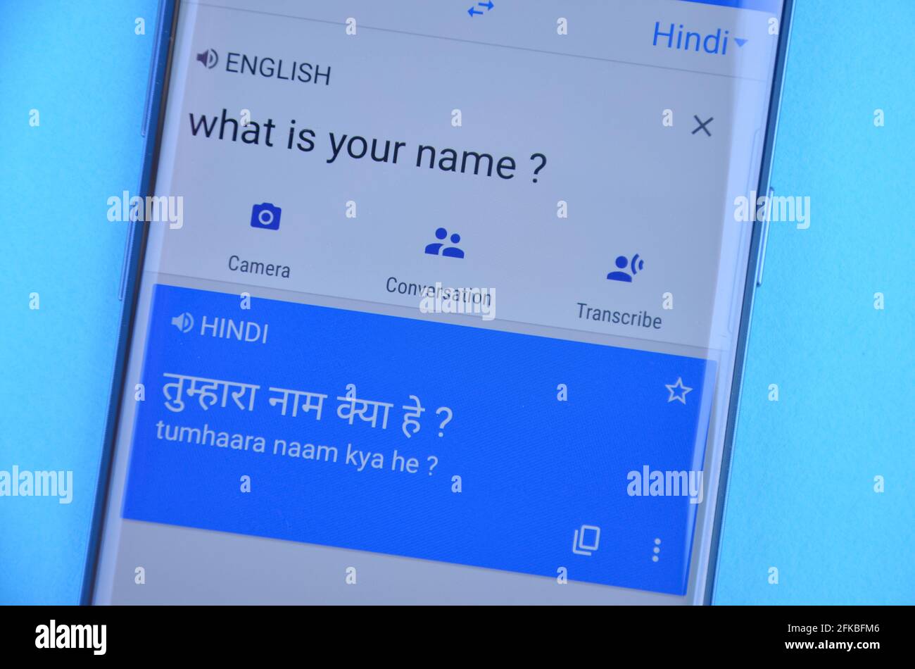 Mandi, Himachal Pradesh, Inde - 03 05 2021: Traduire 'quel est votre nom' anglais en langue hindi sur Google traduire affichage sur téléphone mobile isolé sur fond bleu. Banque D'Images