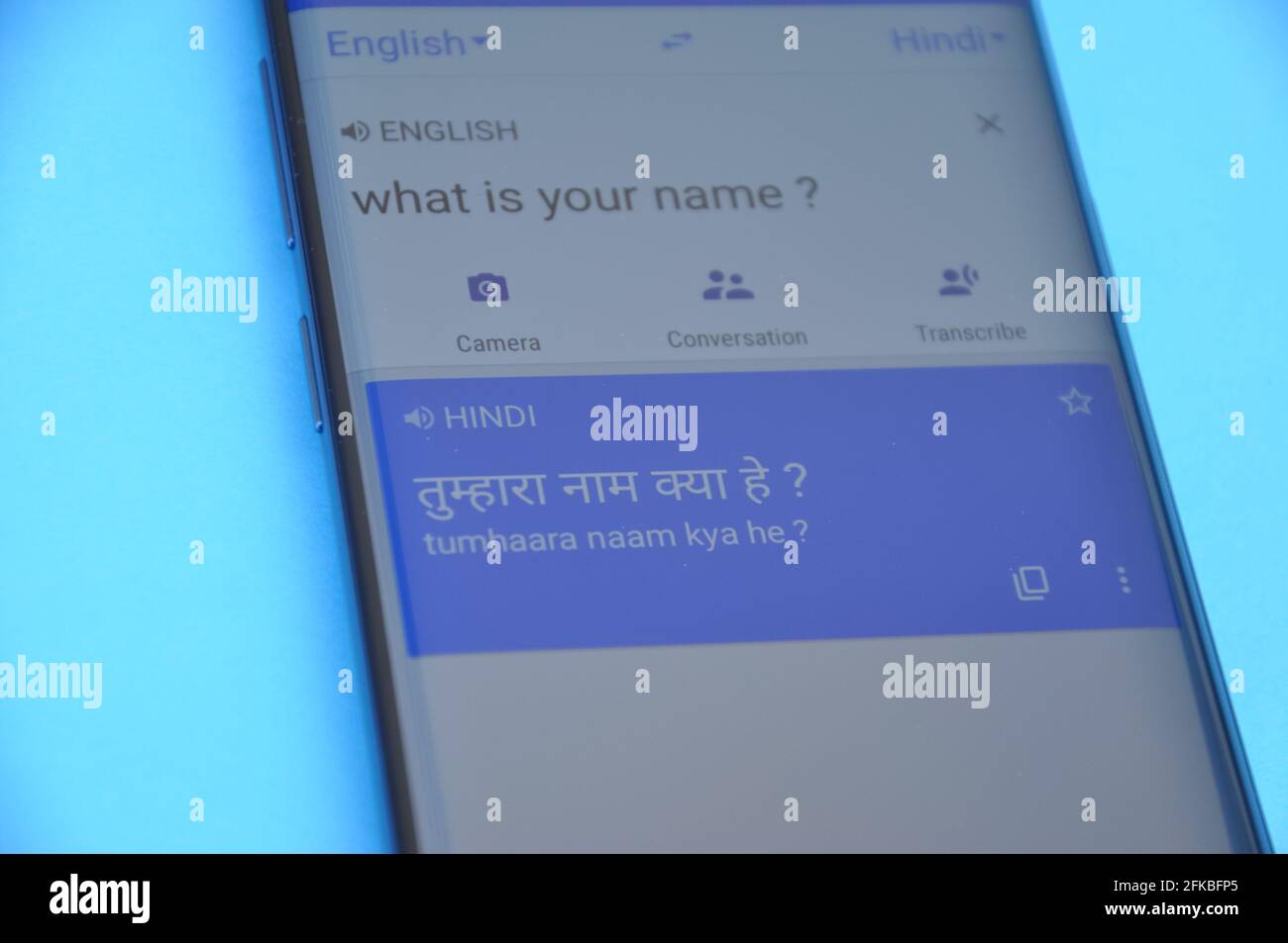 Mandi, Himachal Pradesh, Inde - 03 05 2021: Traduire 'quel est votre nom' anglais en langue hindi sur Google traduire affichage sur téléphone mobile isolé sur fond bleu. Banque D'Images