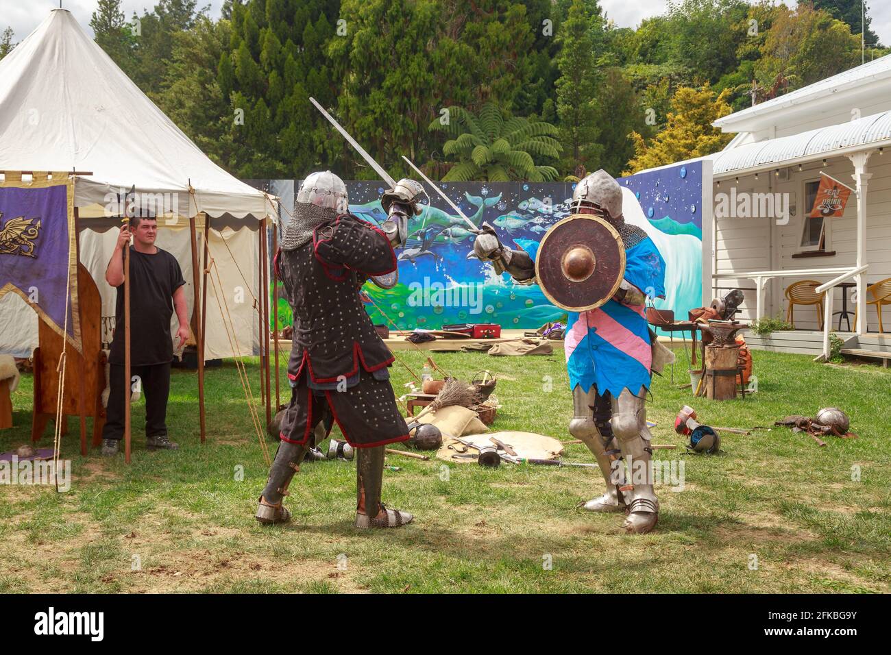 Les réacteurs du Chevalier vêtus de courrier en chaîne et d'armure de plaque, duel avec des épées dans une foire médiévale Banque D'Images
