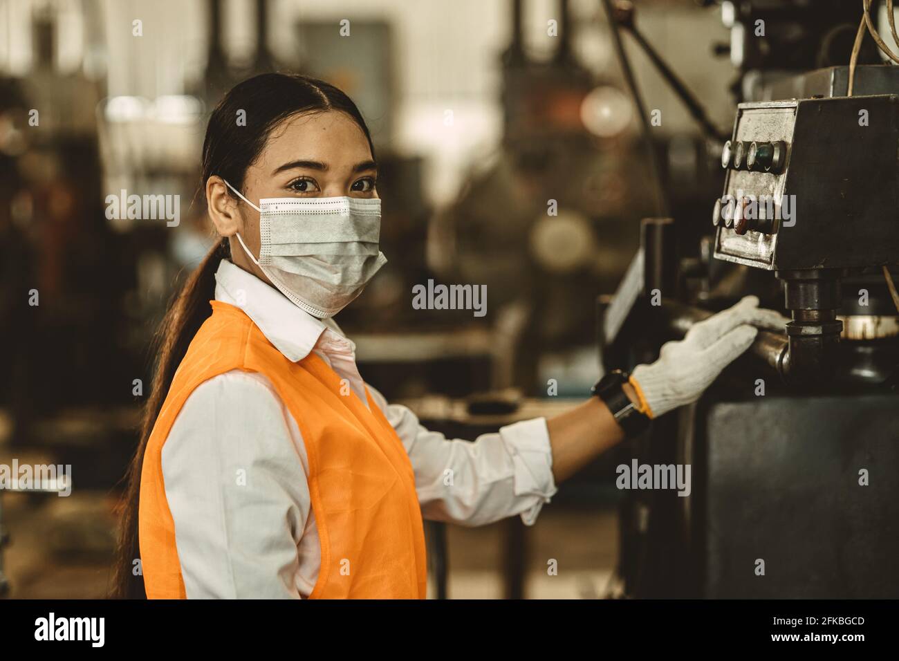 Les femmes portent un masque facial jetable pour la protection Corona virus propagation et fumée filtre à air poussiéreux en usine pour des soins de travail sains. Banque D'Images
