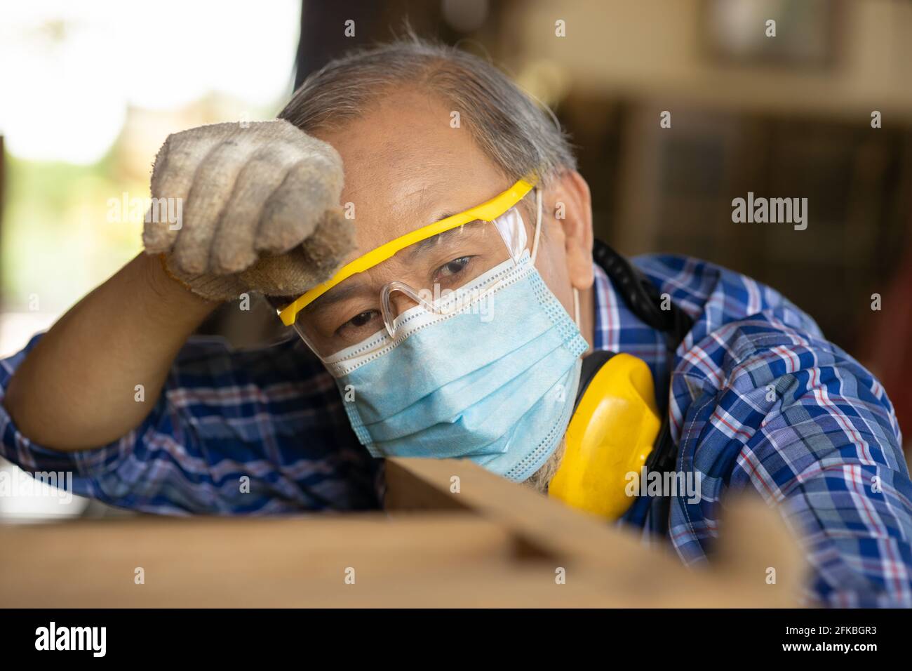 Fatigués épuisés main-d'œuvre asiatique dur travail dans un endroit chaud tête d'essuyage sueur waring masque facial pour COVID-19 et de protection de la poussière. Banque D'Images