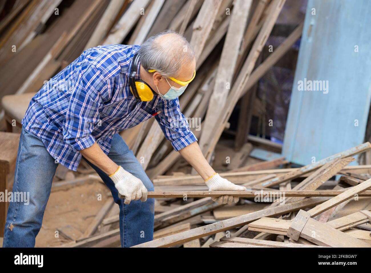 Travailleur aîné bois woodcraft retraite hobby pour la bonne retraite, asiatique homme mature maître professionnel de la fabrication de meubles en bois avec masque protecteur Banque D'Images