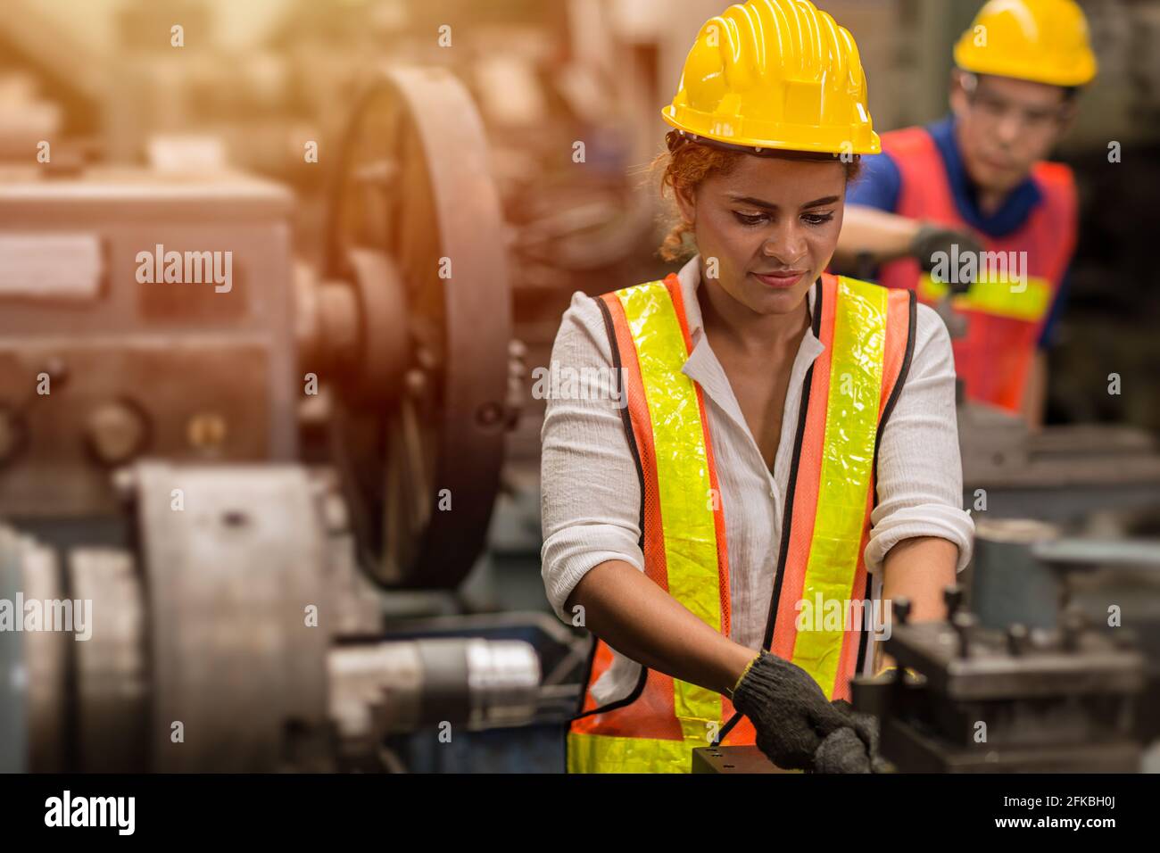 Américaines noires femmes ado travail à temps partiel comme travail dans l'usine de l'industrie avec machine en acier lourd. Banque D'Images