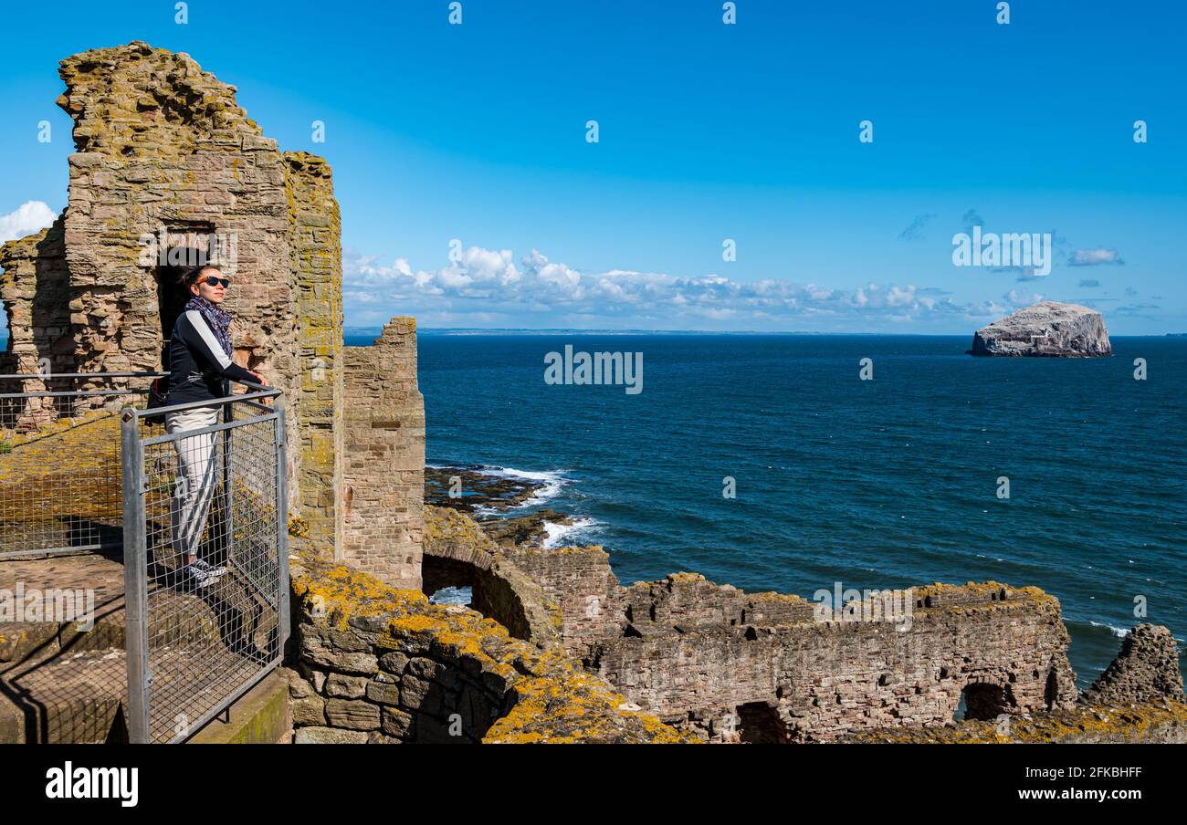 East Lothian, Écosse, Royaume-Uni, 30 avril 2021. Environnement historique Écosse les châteaux médiévaux rouvrent : les premiers visiteurs arrivent par une matinée fraîche et ensoleillée dans des créneaux horaires réservables pour une visite des ruines du château de Tantallon alors que HES rouvre des sites à travers le pays pour la deuxième fois l'année dernière. Sur la photo : Audrey Opdycke-Barnes jouit de la vue pour le sommet des remparts Banque D'Images