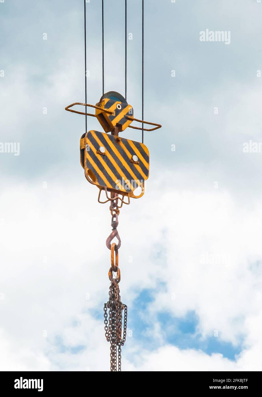 Levage d'un équipement lourd mécanisme de levage d'une grue à tour avec un crochet et une chaîne contre le ciel. Gros plan. Banque D'Images