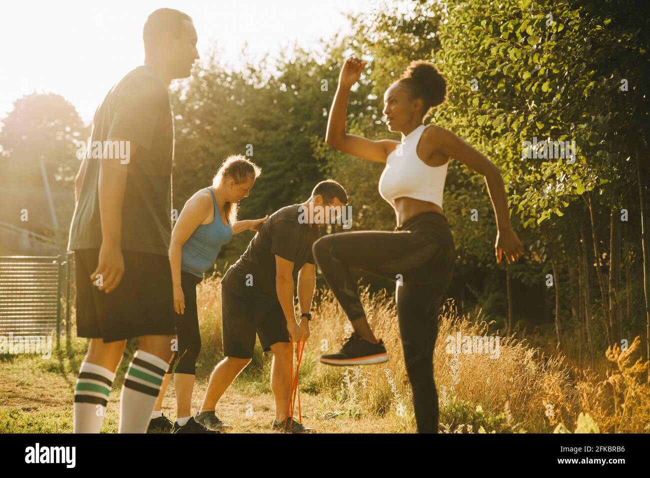 Athlètes masculins et féminins pratiquant l'entraînement sportif dans le parc Banque D'Images