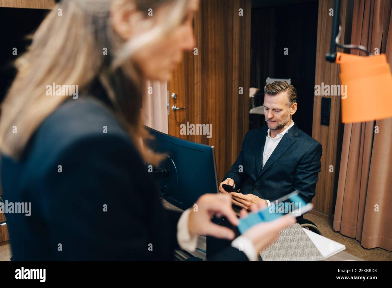 Professionnels utilisant des smartphones au bureau Banque D'Images