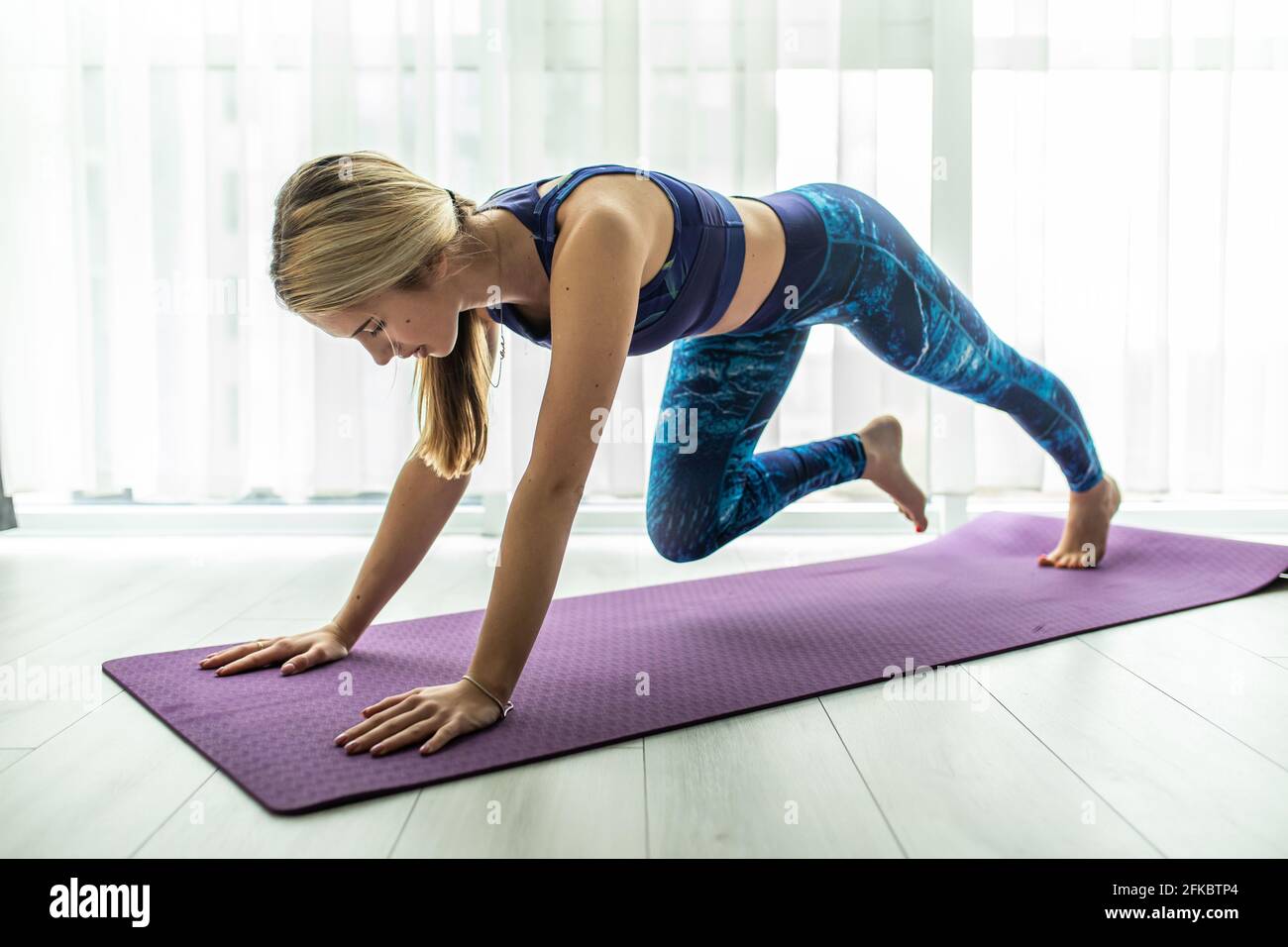 Belle femme en soutien-gorge gris et leggings pratiquant le yoga, faisant  de l'exercice genou-front, phalankasana, variation de la posture de planche  avec la jambe levée, gir Photo Stock - Alamy