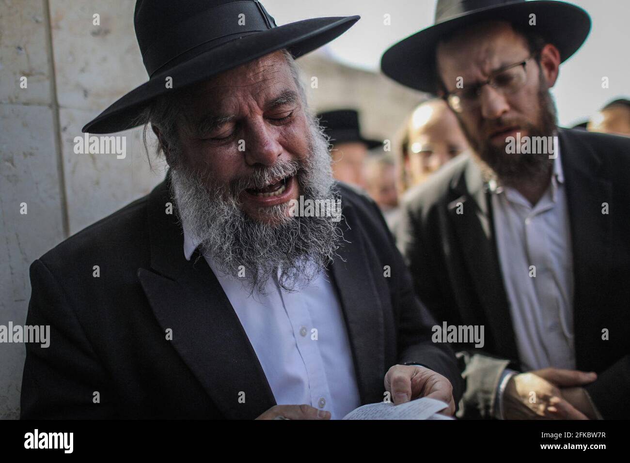 Jérusalem, Israël. 30 avril 2021. Des hommes juifs ultra-orthodoxes pleurent lors des funérailles d'un de ceux qui sont morts dans une bousculade pendant le festival religieux juif de Lag Ba'Omer au lieu de pèlerinage juif orthodoxe du Mont Meron tôt vendredi. Crédit : Ilia Yefimovich/dpa/Alay Live News Banque D'Images