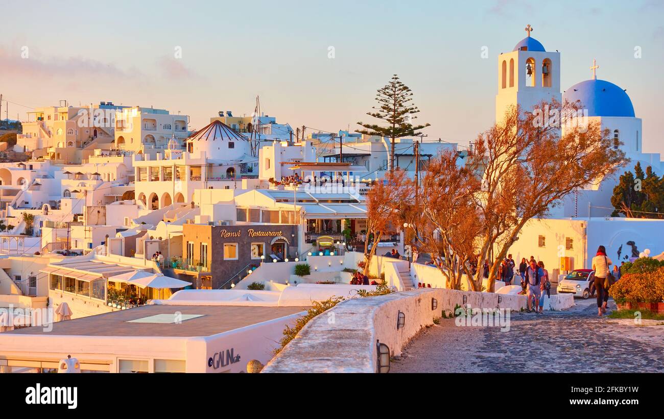 Fira, Santorini, Grèce - 23 avril 2018: Rue dans la ville de Fira dans l'île de Santorini au coucher du soleil. Paysage urbain Banque D'Images