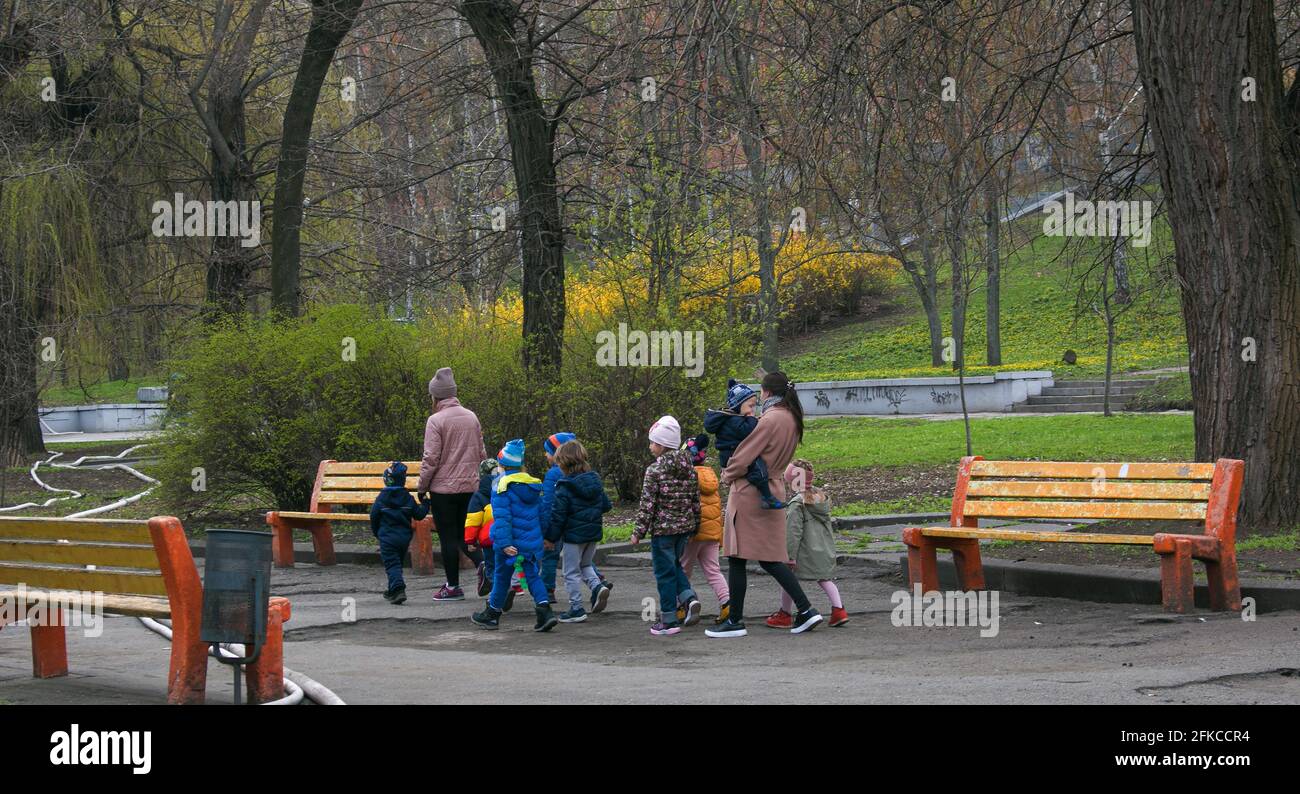 Dnepropetrovsk, Ukraine - 04.19.2021: Les enseignants de la maternelle marchent dans le parc avec les enfants. Banque D'Images