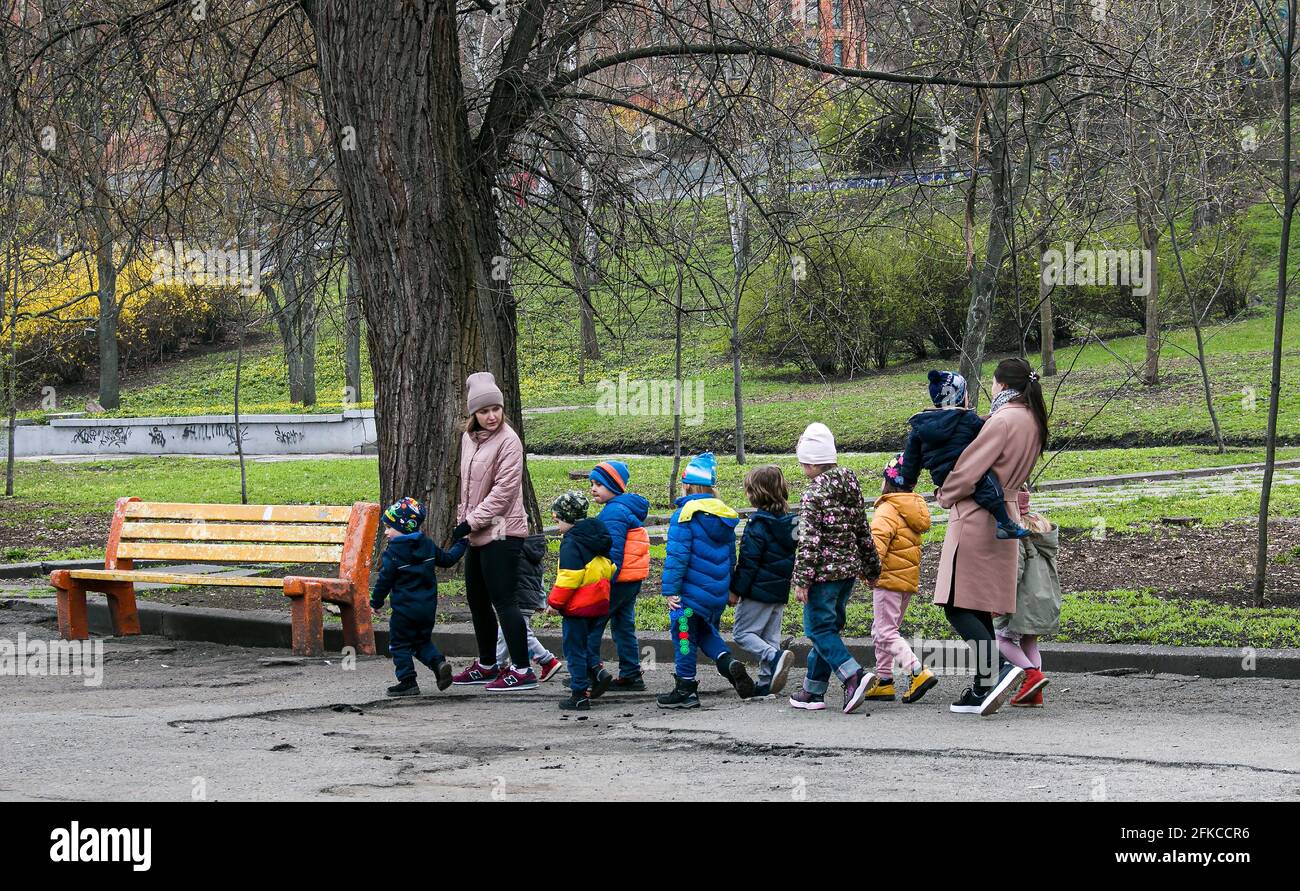 Dnepropetrovsk, Ukraine - 04.19.2021: Les enseignants de la maternelle marchent dans le parc avec les enfants. Banque D'Images