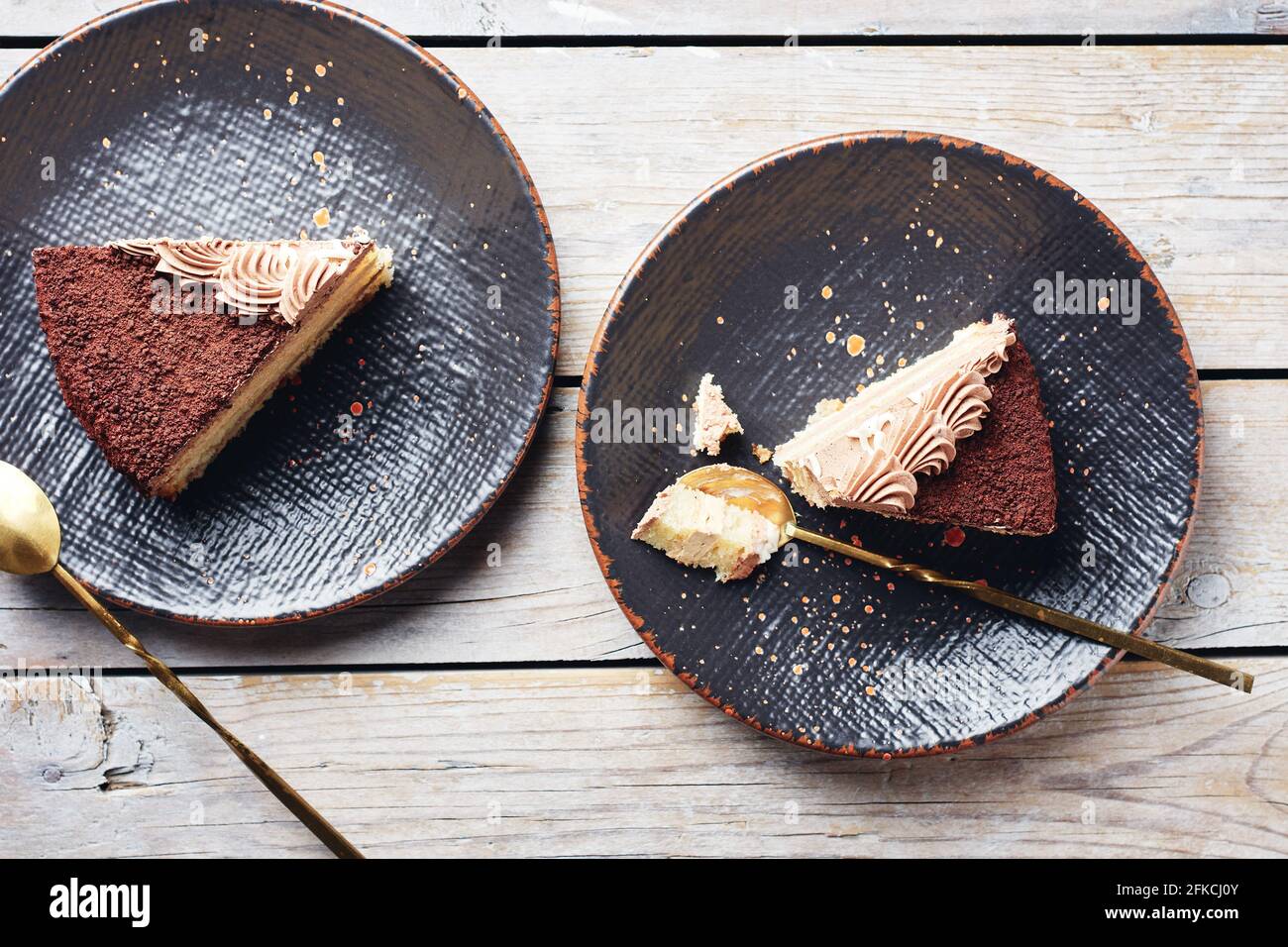 Deux morceaux de gâteau au chocolat sur des assiettes noires, vue du dessus. Banque D'Images