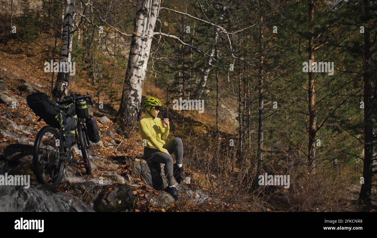 La femme voyage sur le terrain mixte de vélo de tournée avec bikepacking. Le voyage du voyageur avec des sacs de vélo. Sport tourisme bikepacking. Banque D'Images