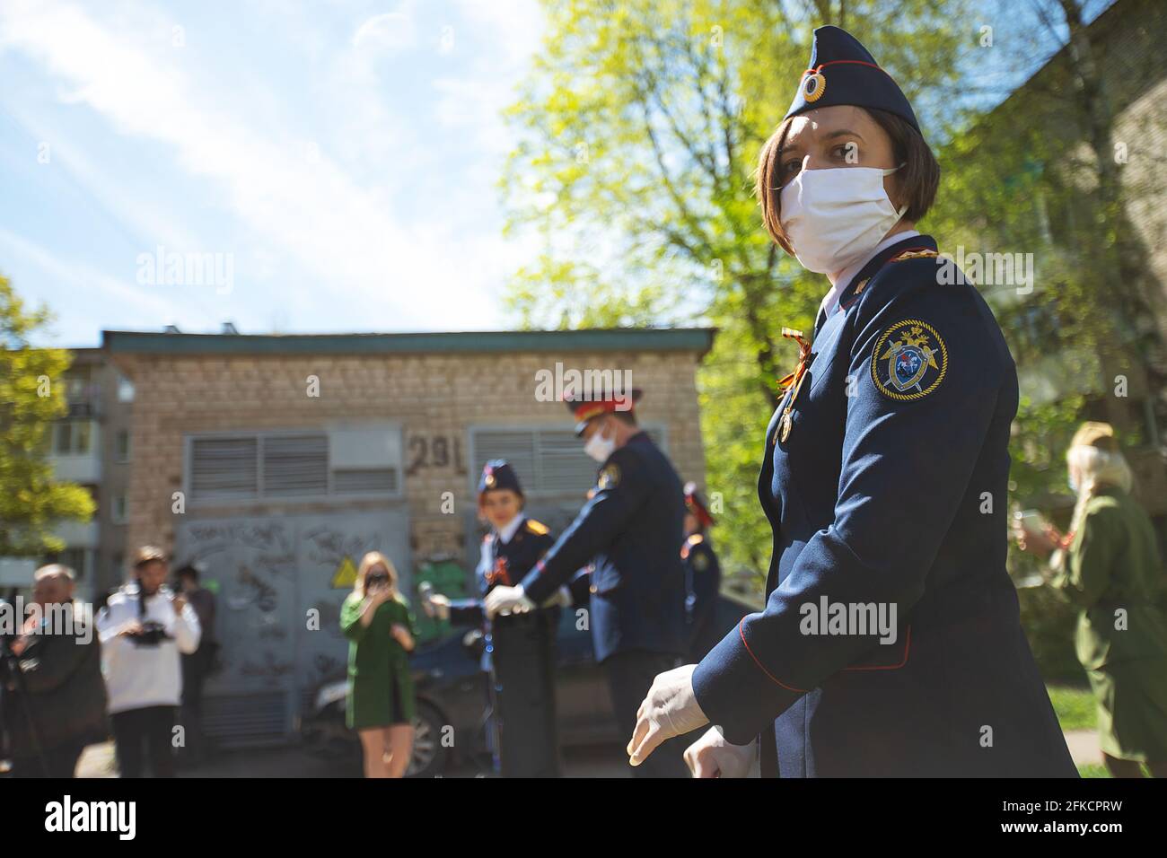 une petite fille dans un uniforme militaire et un masque médical sur son visage. un cortège solennel en fête militaire patriotique Banque D'Images