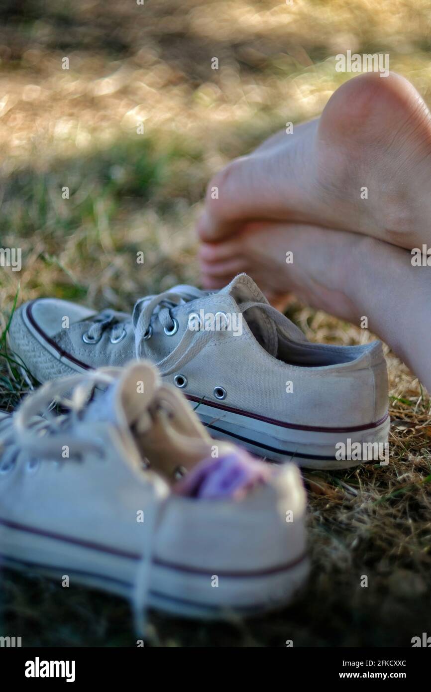 Une partie des pieds d'une jeune femme et une paire de baskets en plein air par temps ensoleillé en France Banque D'Images