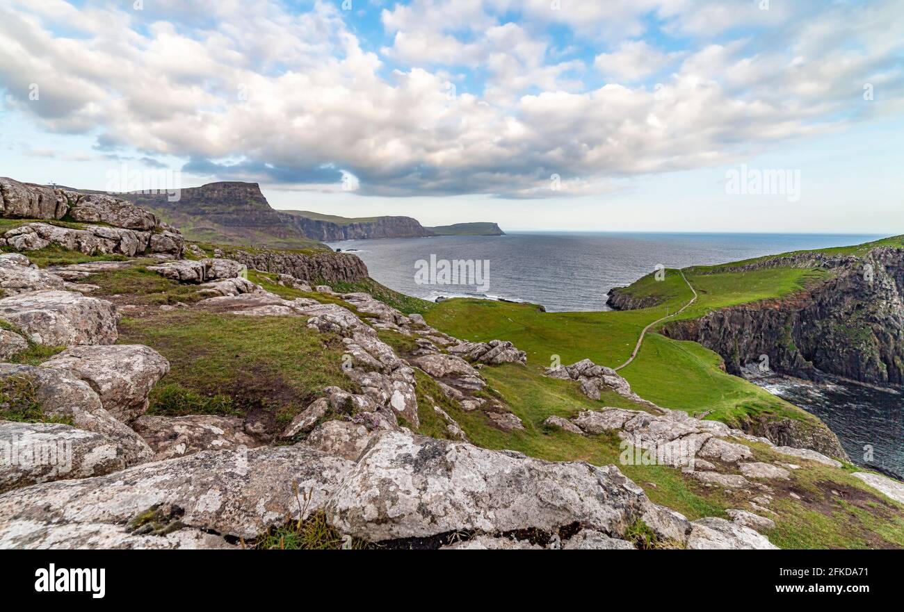 Un gros plan d'une colline à côté d'un corps d'eau et un phare Banque D'Images