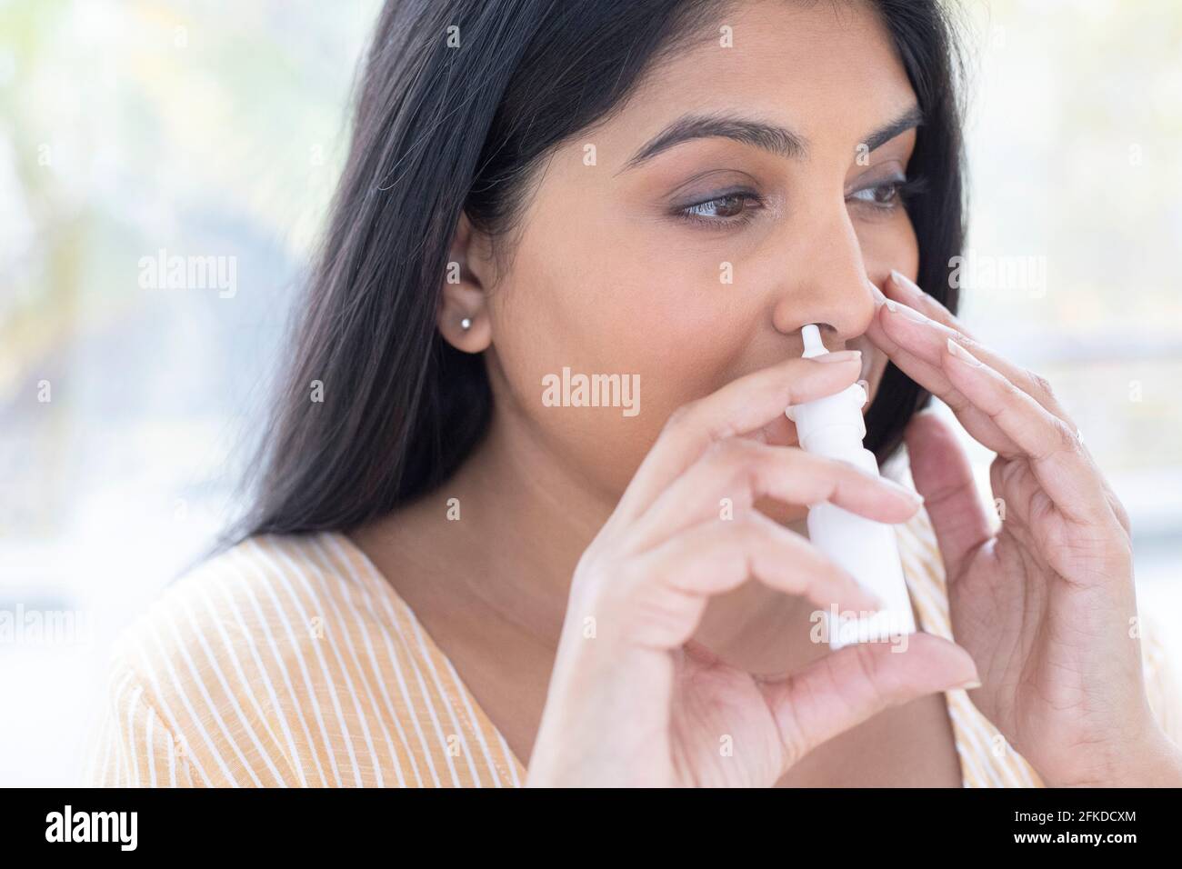Femme à l'aide d'un spray nasal Banque D'Images