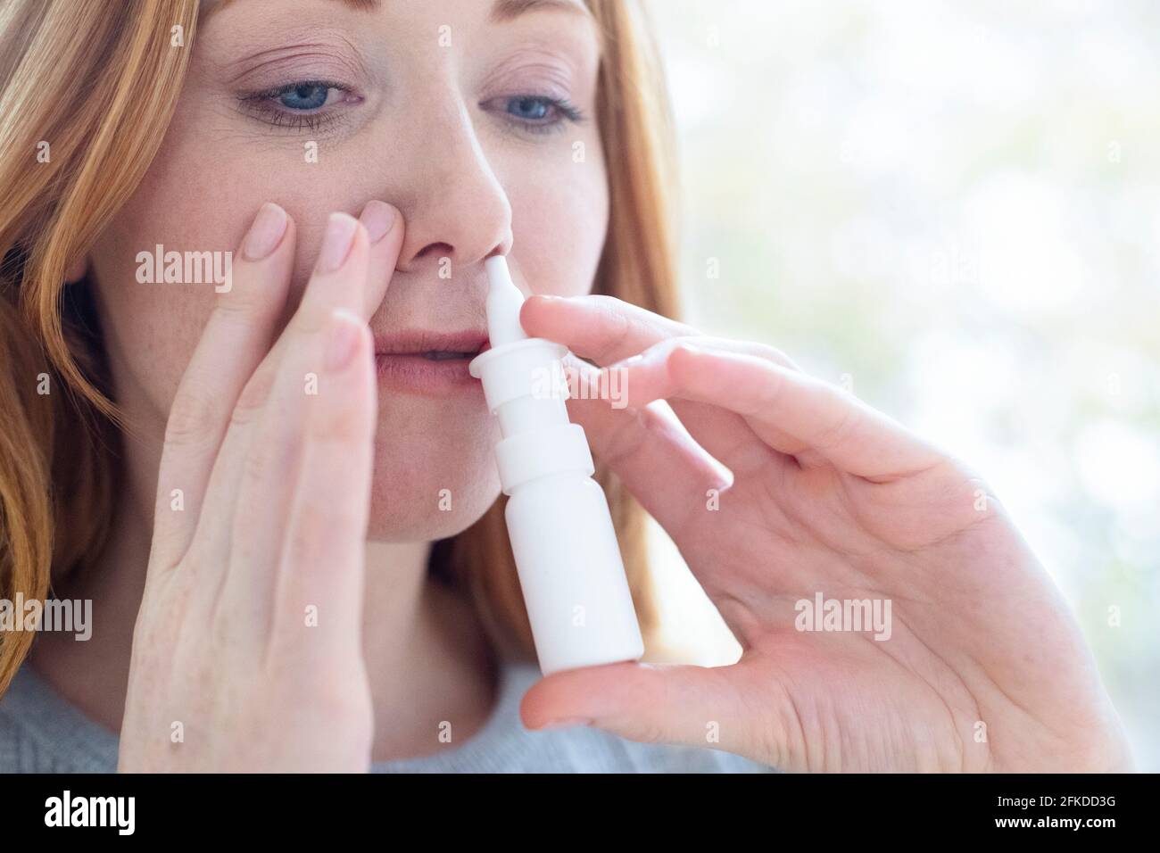 Femme à l'aide d'un spray nasal Banque D'Images