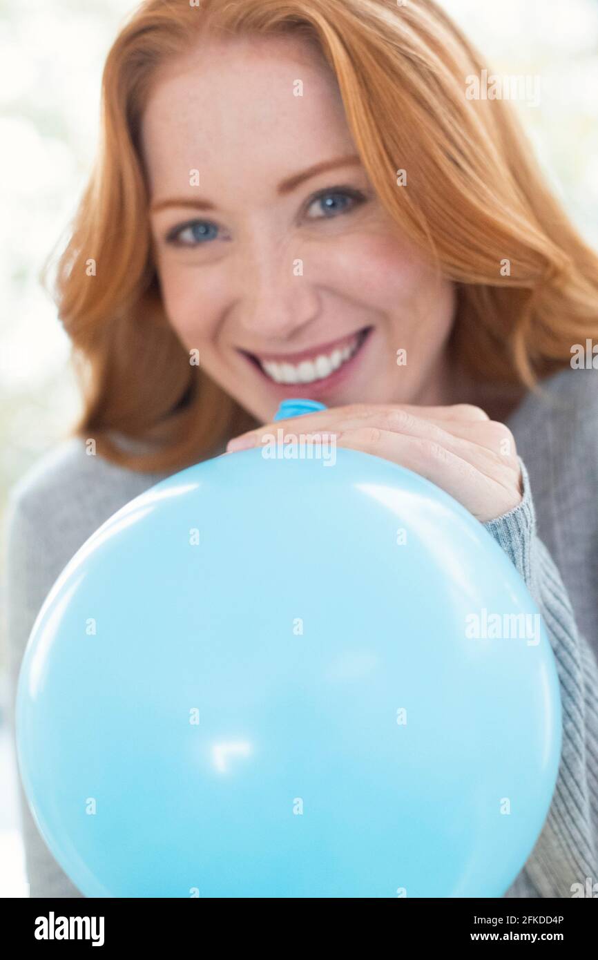 Woman Blowing up balloon Banque D'Images