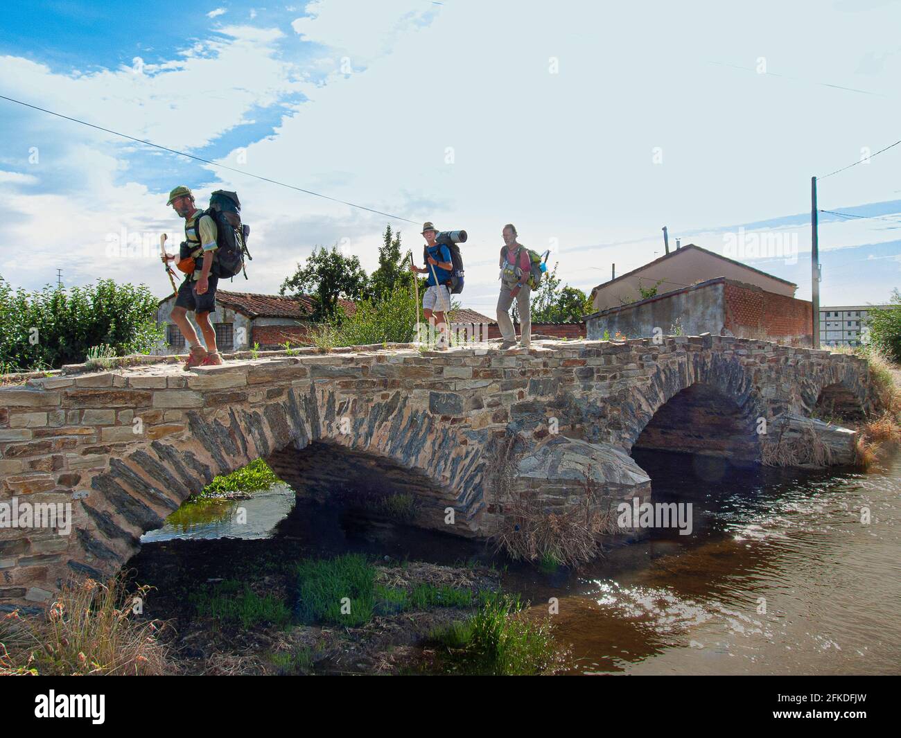 Trois pèlerins sur la Puente de la Molinera, un pont romain en route vers Saint-Jacques-de-Compostelle à l'entrée d'Astorga, Espagne, le 16 juillet 2010 Banque D'Images