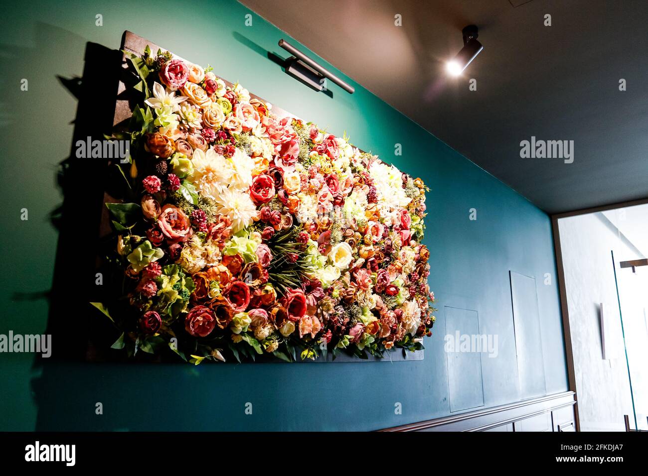 Mur de fleurs artificielles Décoration fleurs Rose soie fleurs dans le  centre de spa de luxe contre un mur bleu Photo Stock - Alamy