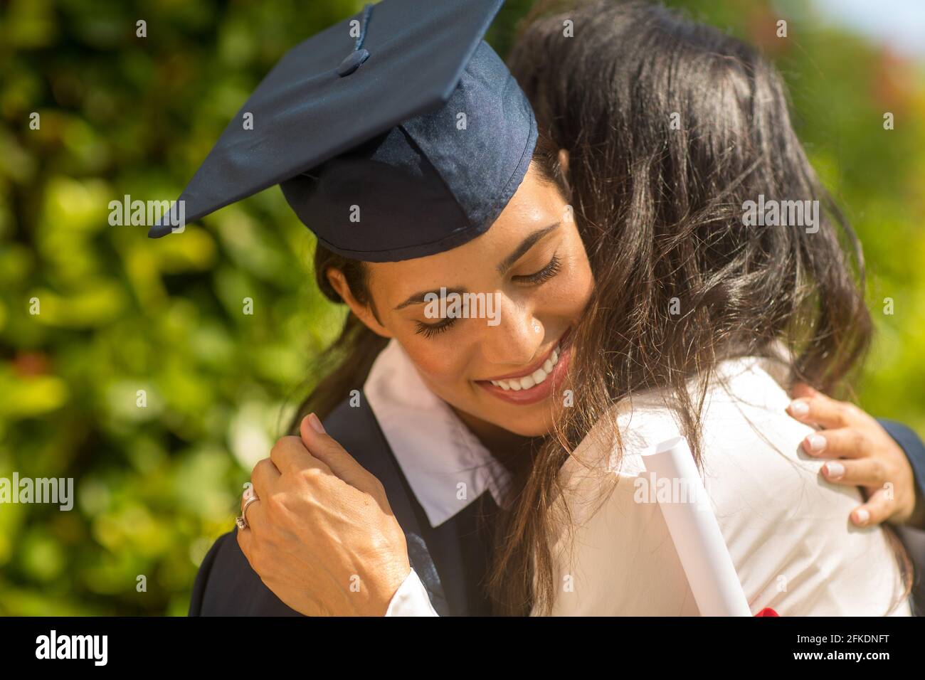 Mère embrassant sa fille à son diplôme Banque D'Images