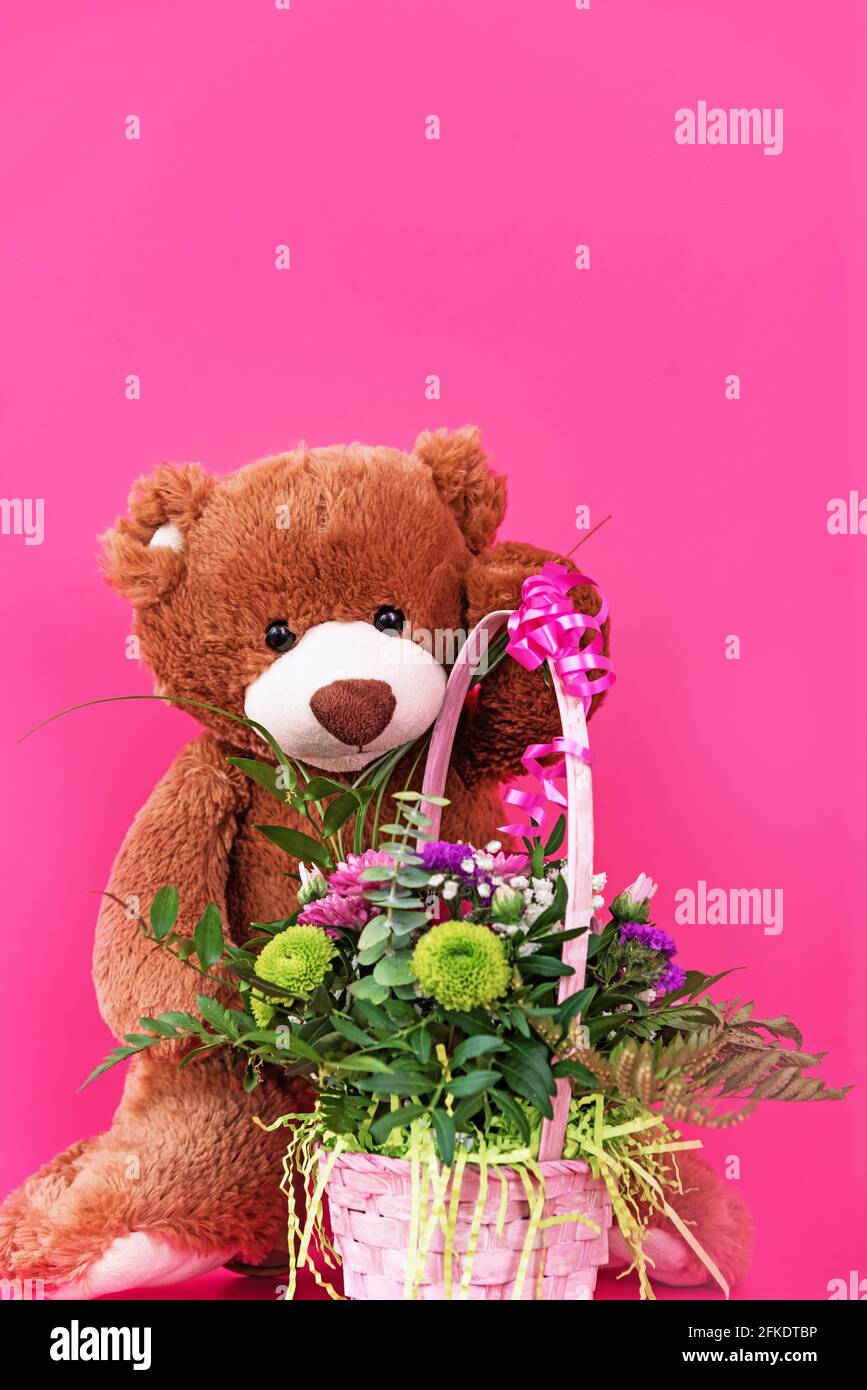 Ours en peluche contenant une carte vierge et un petit bouquet de couleur rose Banque D'Images