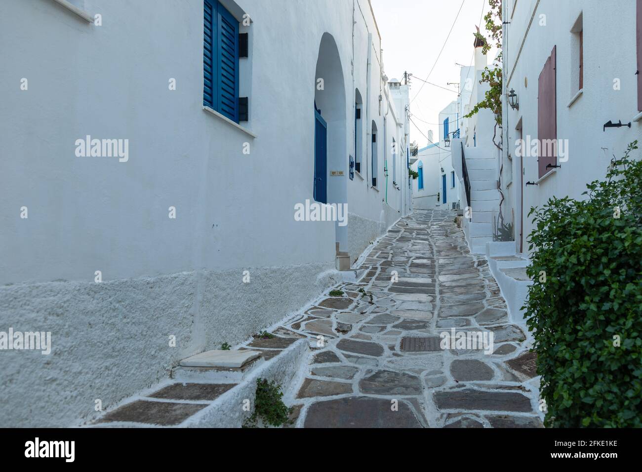 Rue étroite de la vieille ville. Architecture traditionnelle et un chemin en pierre avec des joints blancs. Lefkes, île de Paros, Grèce. Banque D'Images