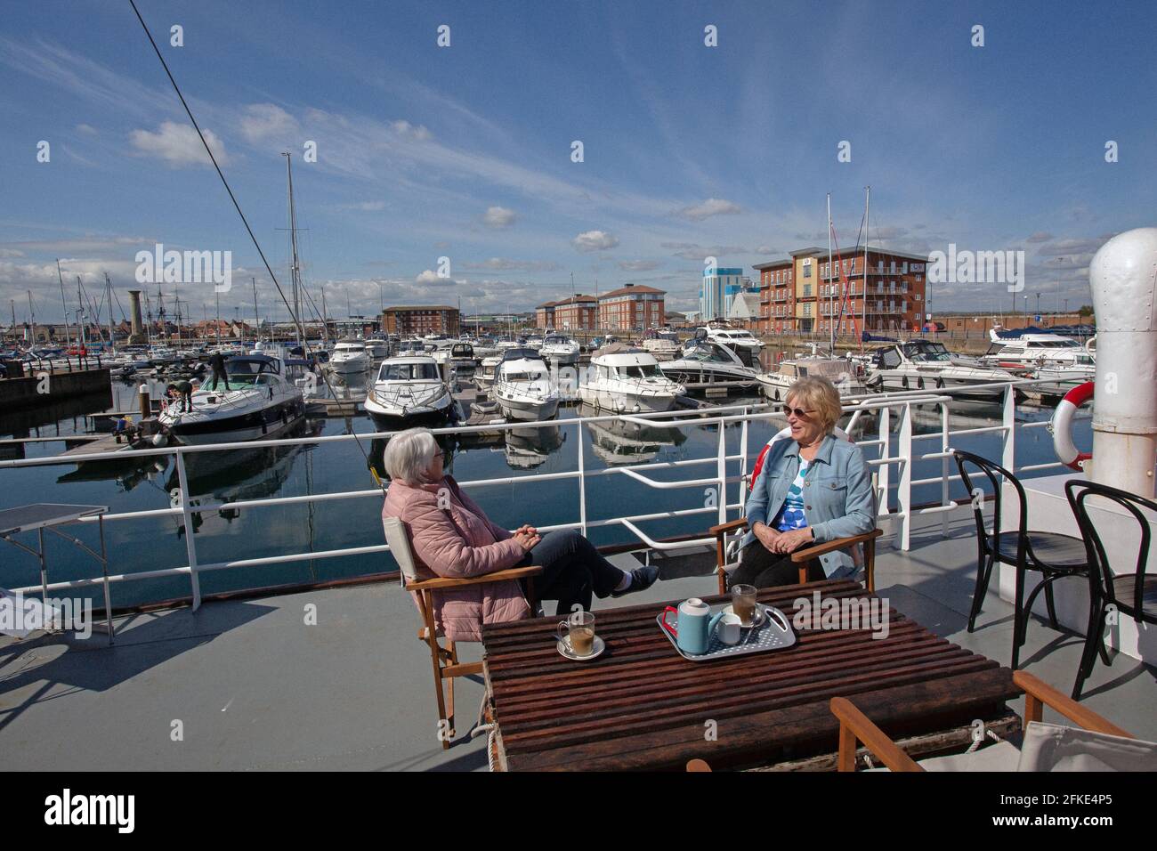 Deux femmes prenant le thé au petit bateau nouvellement restauré de Dunkirk qui a été transformé en café-restaurant à la marina de Hartlepool, Angleterre, Royaume-Uni. Banque D'Images