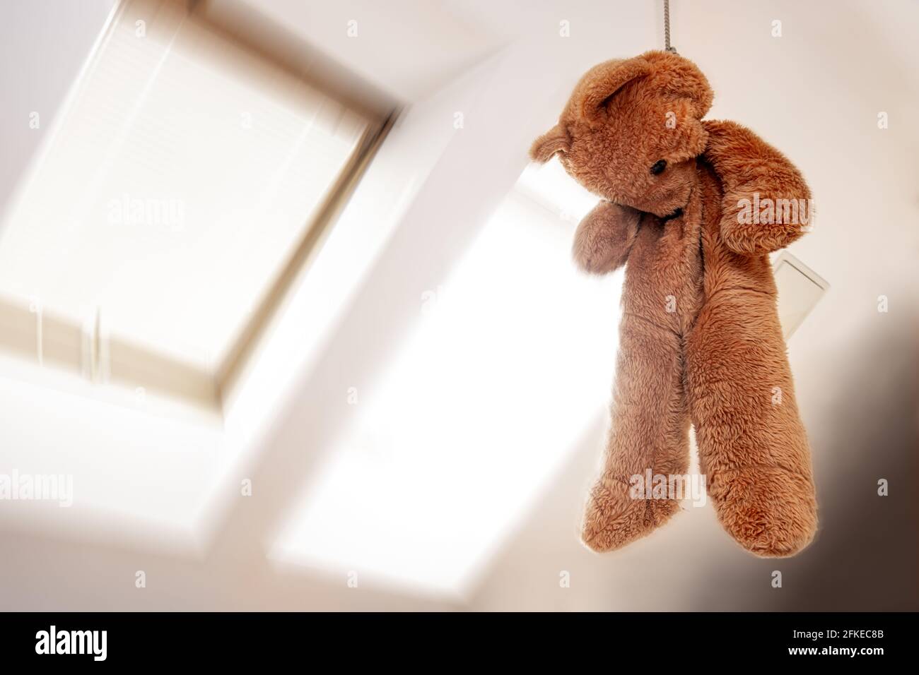 Un ours en peluche suspendu dans un nœud dans le grenier chambre Banque D'Images