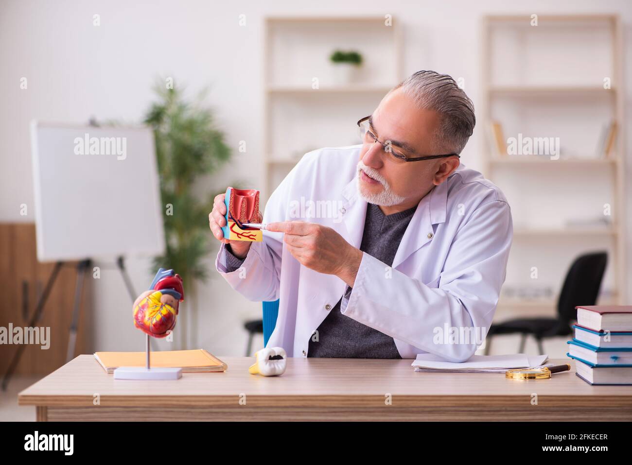 Ancien professeur de dentiste assis dans la salle de classe Banque D'Images