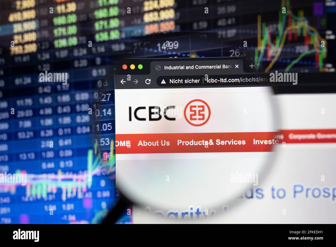 Le logo de la société ICBC sur un site Web avec des développements flous du marché boursier en arrière-plan, vu sur un écran d'ordinateur à travers une loupe Banque D'Images
