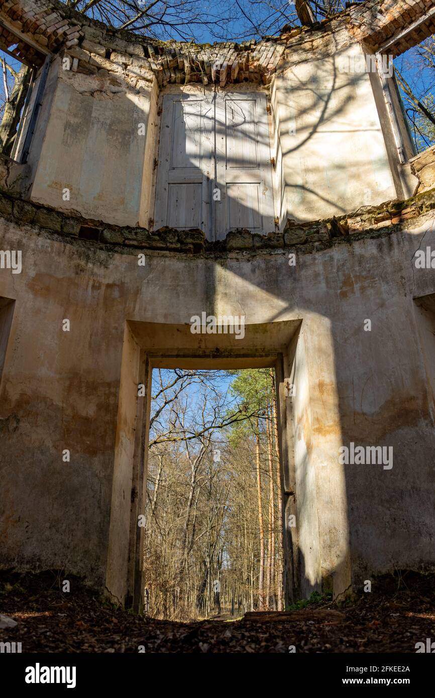 Vue à travers un trou pour les portes et les fenêtres dans un ruine abandonnée dans les bois Banque D'Images