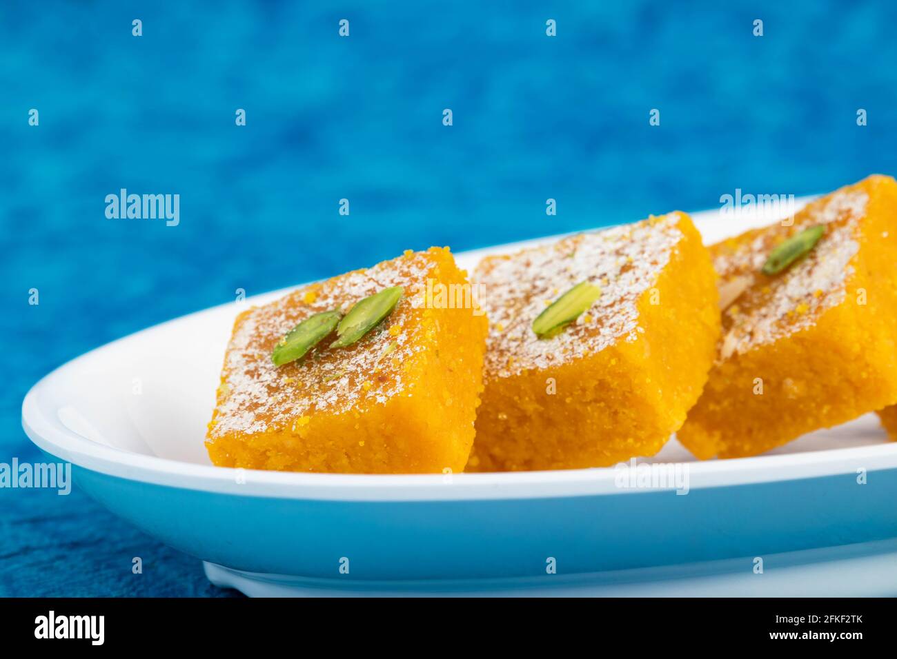 Traditionnel indien Mithai Moong Dal Burfi ou Meetha Mung Daal Barfi Barfee cuisiné à Desi ghee dans un plateau blanc Angle bas vu du côté O. Banque D'Images