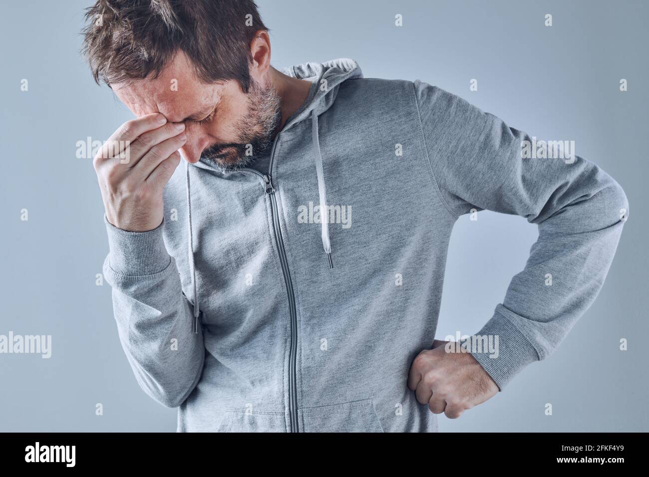 Homme caucasien adulte avec maux de tête de tension sévère, expression faciale douloureuse Banque D'Images