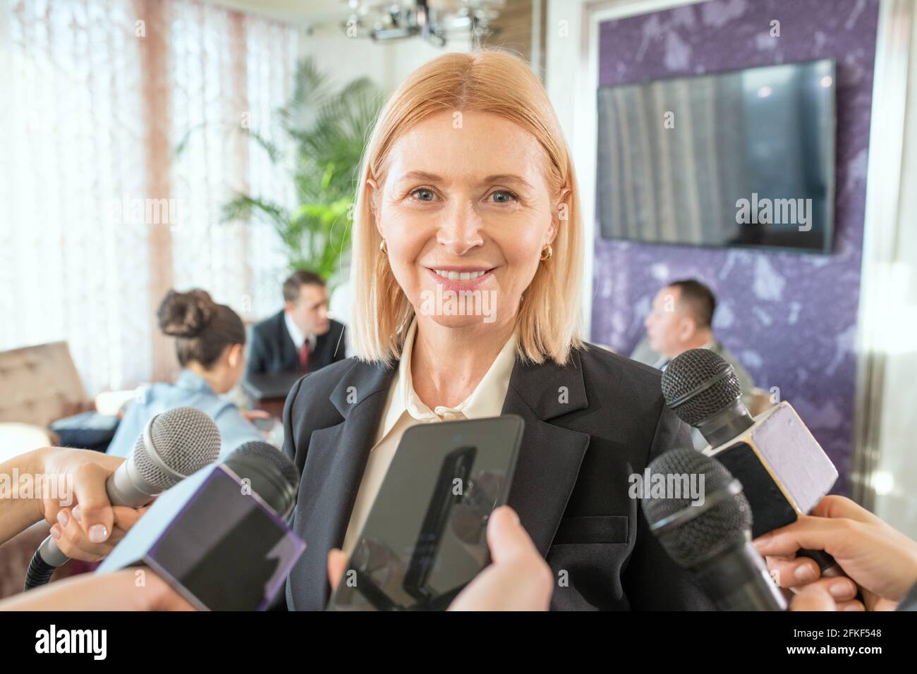 Une femme qui parle dans le microphone lors d'une conférence en face de appareil photo Banque D'Images