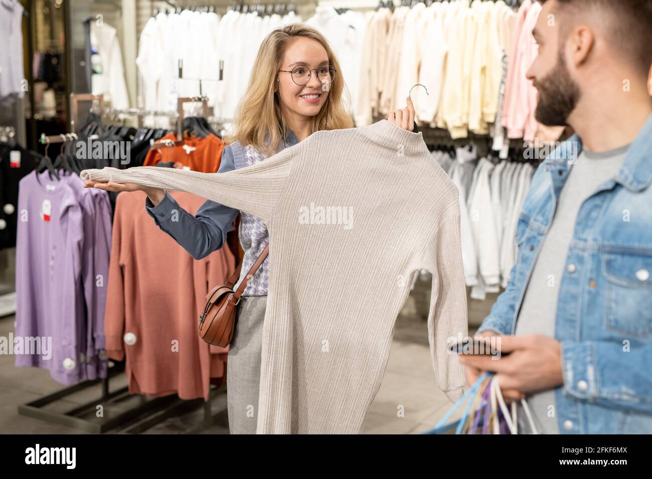 Un homme et une femme choisissant de nouveaux vêtements tout en faisant du shopping Banque D'Images
