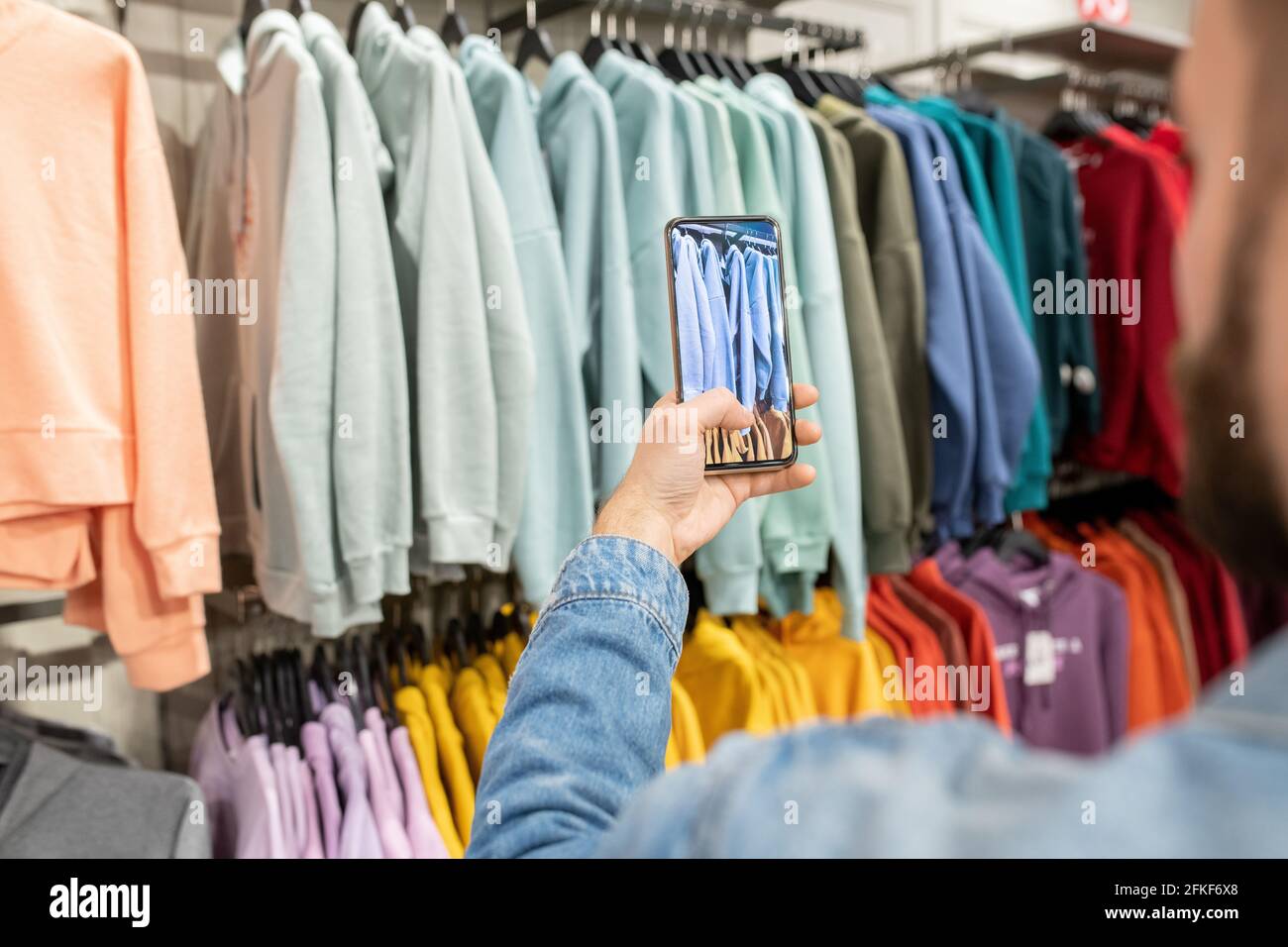 Une personne prenant des photos de la nouvelle collection de mode pendant le shopping Banque D'Images