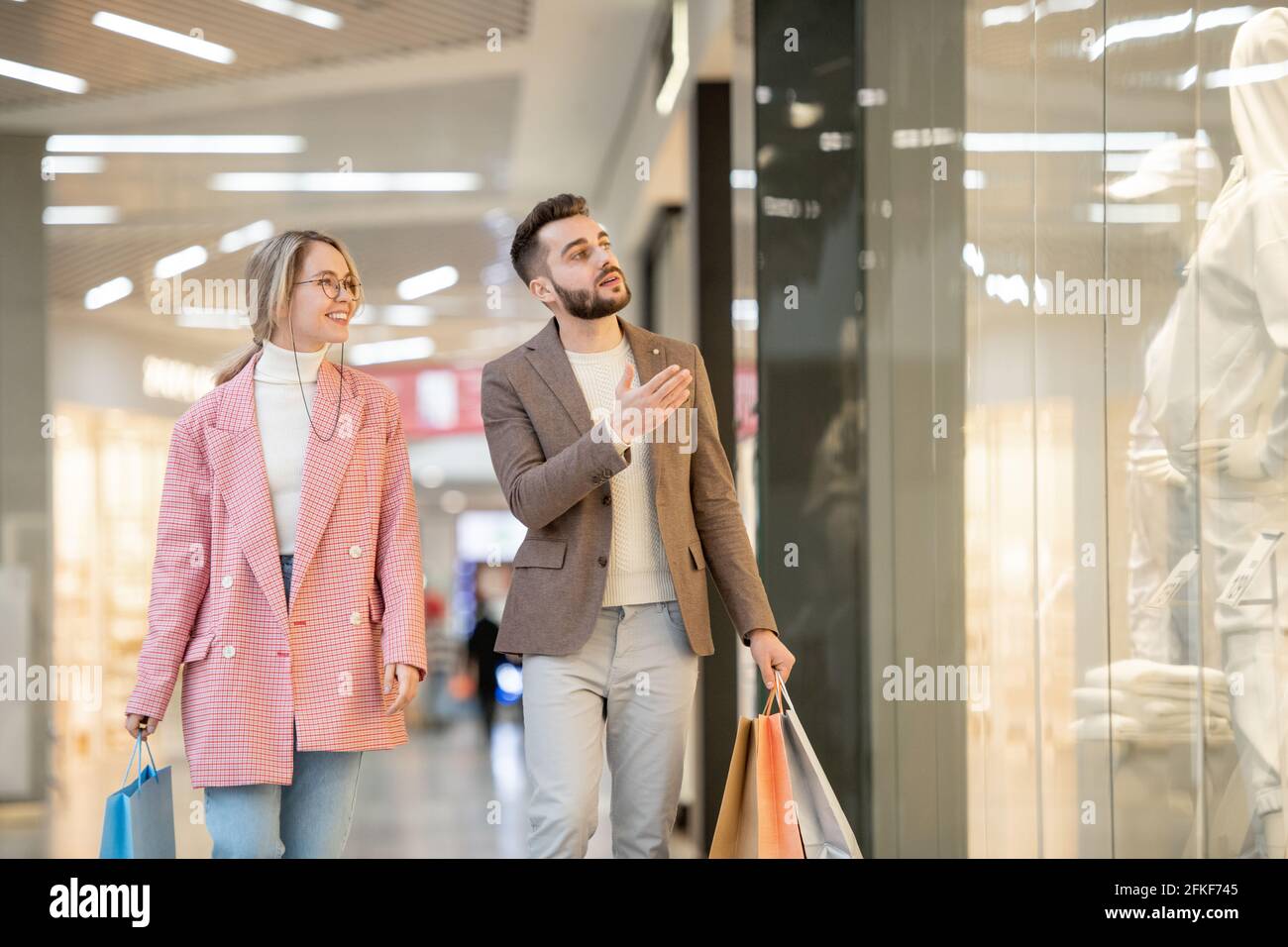 Un homme et une femme qui magasinent dans un centre commercial contemporain Banque D'Images