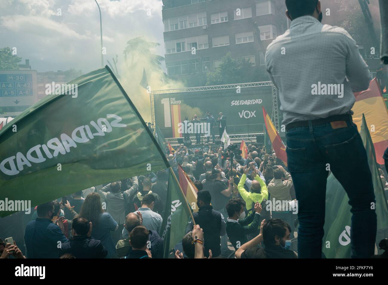 Les fans de VOX applaudissent au milieu de la fumée des fusées de la Plaza Conde de Casal.dans le cadre de la Journée internationale du travail du 1er mai, le parti d'extrême-droite espagnol VOX lance le syndicat "Solidaridad". Avec des discours anti-communistes, anti-écologiques, anti-illégaux, anti-féministes et ultra-nationalistes, Santiago Abascal, président de VOX, Rocio Monasterio, candidat aux élections de la Communauté de Madrid, et Rodrigo Alonso, secrétaire général du syndicat Solidaridad ont participé à la réunion sur la Plaza de Comte Casal. La loi a lieu quelques jours avant les élections Banque D'Images