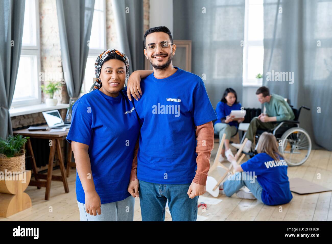 Un groupe de jeunes interculturels heureux en t-shirts bleus poser pour une photo Banque D'Images