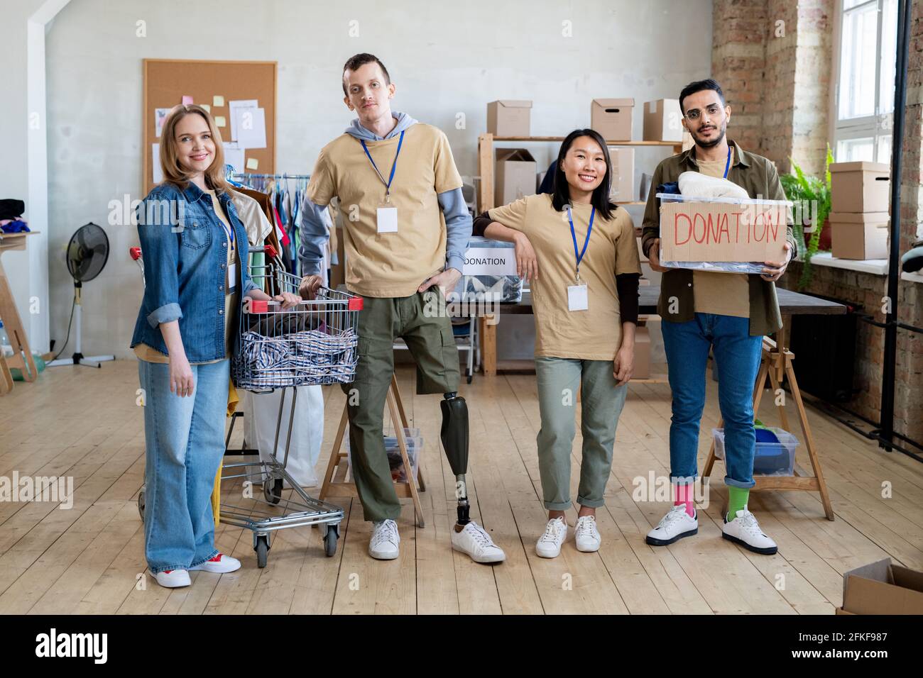 Un groupe de personnes avec des vêtements de don debout dans le bureau Banque D'Images