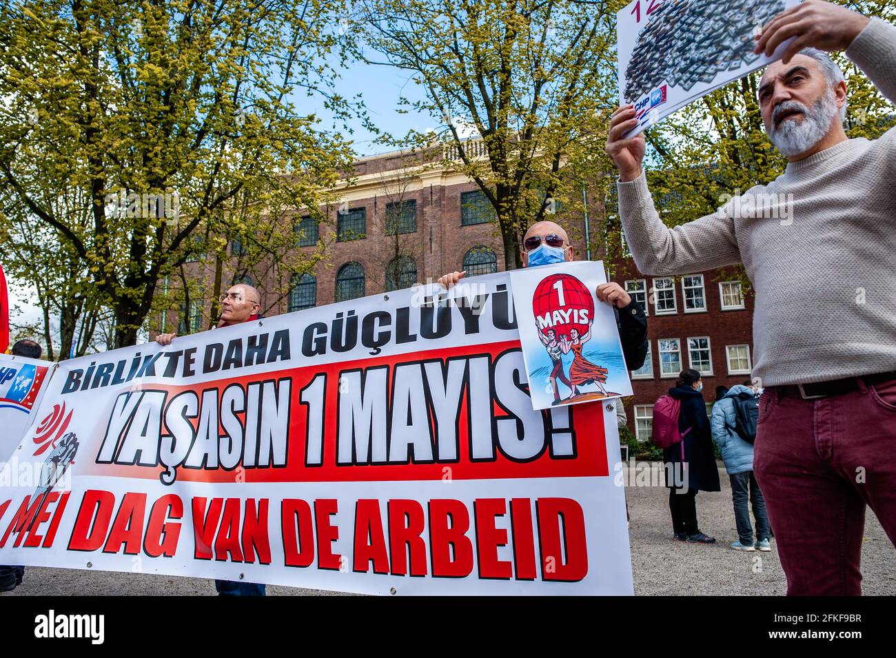 Amsterdam, pays-Bas. 1er mai 2021. Un groupe d'hommes turcs tient une grande bannière pendant la manifestation.le jour de la Journée internationale du travail, également connue sous le nom de Fête du travail, à Amsterdam, les gens se sont rassemblés sur la place Jonas Daniël Meijer pour exiger des conditions de travail équitables telles qu'un salaire minimum de 14 euros par heure, des contrats permanents, un bon logement social, un bon système de retraite, un accès gratuit à des soins de santé complets (mentaux) et une éducation gratuite. Crédit : SOPA Images Limited/Alamy Live News Banque D'Images