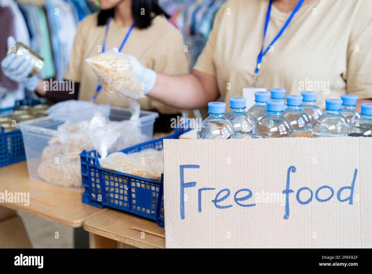 Volontaires servant gratuitement de la nourriture et des bouteilles en plastique avec de l'eau Banque D'Images